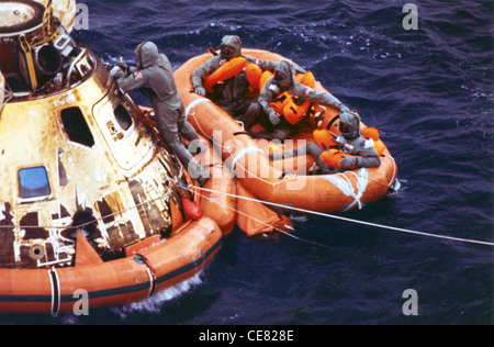 First LT. Clancy Hatleberg schließt die Raumsonde Apollo 11, als die Astronauten Neil Armstrong, Michael Collins und Buzz Aldrin Jr. 1969 auf die Abholung vom Rettungsboot warten. Das Kommandomodul wurde von der Patrick Air Force Base, Fla. Für die Modernisierung von Pararescuemen verwendet, um sowohl für die Apollo- als auch für die Skylab-Programme zu trainieren. Der 920th Rescue Wing bietet medizinische Nothilfe, Rettungs- und Erholungsunterstützung für alle Space Shuttle und Raketenstarts. Stockfoto