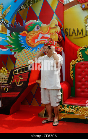 Mann, der versucht auf einen Kopfschmuck in einem Schaufenster in Bangkok für Chinese New Year. Stockfoto