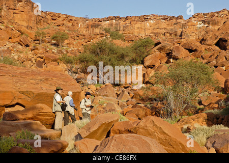 Touristen, die San rock Kunst vor Ort, Twyfelfontein, Namibia Stockfoto