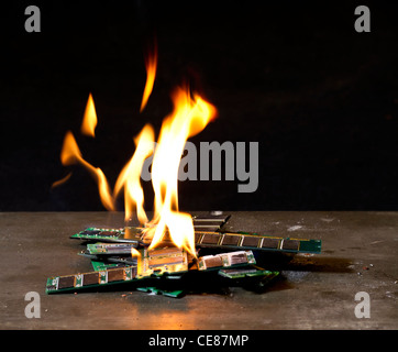 kleine Haufen brennenden RAM-sticks vor dunklen Rücken Stockfoto