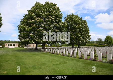 Gedenkstätte und Gräber unter blühenden Kastanienbäumen im Bayeux War Cemetery - Der britische Soldatenfriedhof in Bayeux, Normandie. Bayeux Soldatenfriedhof. Stockfoto