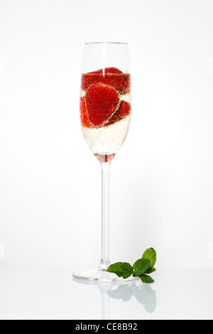 Glas Sekt und Erdbeeren auf weißem Stockfoto