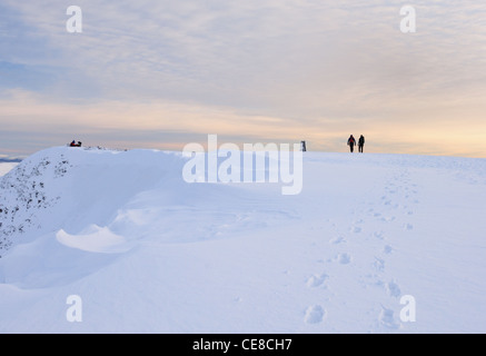 Wanderer machen Spuren auf dem Gipfel des Lakelandpoeten im Winter im englischen Lake District Stockfoto