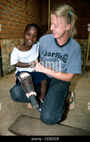 Eine Krankenschwester hält einen kleiner Junge, der ein Holzbein hat, nachdem er sein Bein in einer Grube Explosion während des Krieges in Ruanda, Afrika verloren Stockfoto