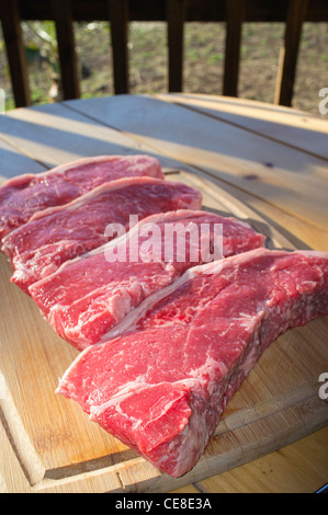 New York Strip Steaks auf Schneidebrett Stockfoto