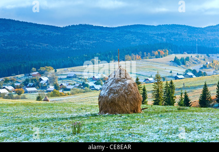 Erster winter Schnee am Oktober Karpaten Bergplateau mit Dorf und Autobahn weit weg Stockfoto