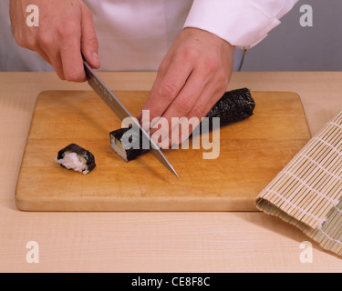 Maki - Sushi Schritt 6: geschnittene Brötchen mit feuchten Messer in kleine Röllchen Stockfoto