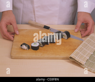Maki - Sushi Step 7: Maki-Rolle geschnitten Stockfoto