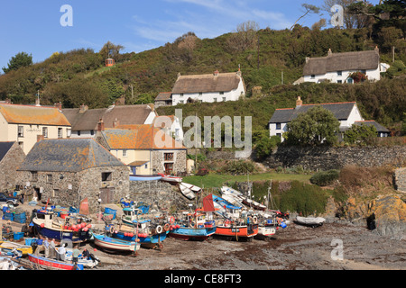 Cornish Fischerdorf mit strohgedeckten Hütten und Boote am Ufer im kleinen Hafen. Cadgwith, Cornwall, England, Großbritannien, Großbritannien. Stockfoto