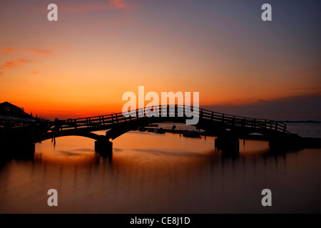 Sonnenuntergang in Lefkas Stadt, in der kleinen Marina für die Fischerboote mit schöne Holzbrücke. Ionische Inseln, Griechenland. Stockfoto