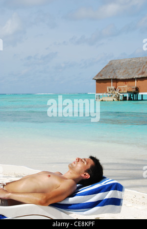 Junger Mann, Sonnenbaden auf den Malediven Stockfoto