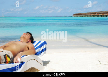 Junger Mann, Sonnenbaden auf den Malediven Stockfoto