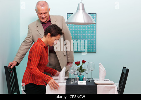 Foto von ein älteres paar anreisen und an ihrem reservierten Tisch in einem Restaurant sitzen Stockfoto