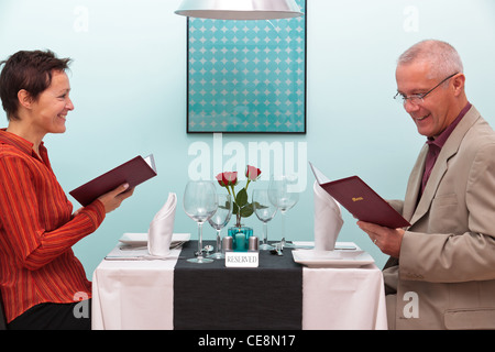 Foto von ein älteres Paar, sitzen in einem Restaurant, das Lesen der Speisekarte Stockfoto