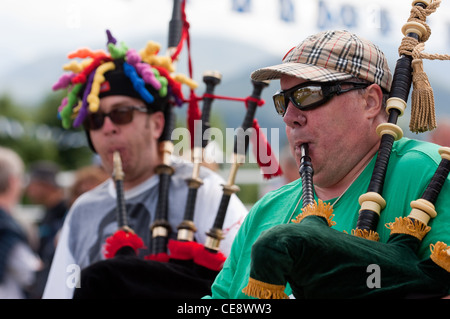 Männer in Kilts und lustige Hüte und Sonnenbrillen spielen Dudelsack beim Homecoming Event auf dem Caledonian canal Stockfoto