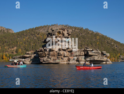 Touristen mit kleinen Booten um die Lady Rock in Burabay See, Kasachstan Stockfoto