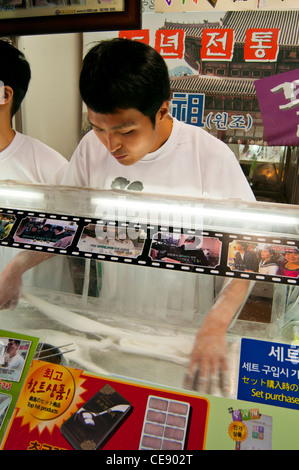 Stall, Verkauf von traditionellen koreanischen Süßigkeiten mit einem jungen Mann zeigt, wie sie Kunden, Insadong, Jongno-Gu gestellt werden Stockfoto