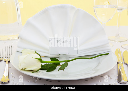 Foto von einer Tischdekoration Ort für eine Hochzeit mit einer weißen Rose auf dem Teller. Stockfoto