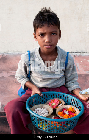 Junge kleine Behälter mit Blumen und Chapati-Brot für eine Puja, Rishikesh, Uttarakhand, Indien zu verkaufen Stockfoto