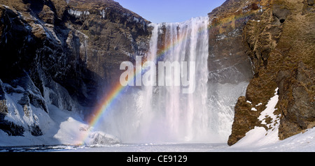 dramatische isländische Wasserfall zeigt einen bunten Regenbogen Stockfoto