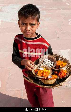 Junge verkaufen Diyas, (Blume Schwimmer), kleine Behälter mit Blumen und Chapati-Brot für eine Puja, Rishikesh, Uttarakhand, Indien Stockfoto