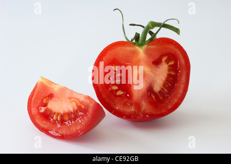 Tomate (Lycopersicon Esculentum), halbierte Früchte. Studio Bild vor einem weißen Hintergrund. Stockfoto