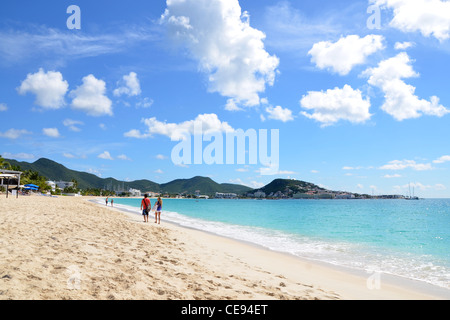 Ein junges Paar, das an einem sonnigen Tag an einem sandigen Strand spazieren geht. Entspannter und unbeschwerter Urlaub auf der karibischen Insel Saint Martin/Sint Maarten. Stockfoto