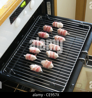 Ungekocht Schweine In decken (eingewickelt in Speck Würstchen) auf einem Grill Pan Stockfoto