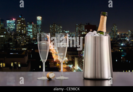 USA, Illinois, Metamora, Champagner Flöten und Flasche im Eiskübel mit im Hintergrund die Skyline der Innenstadt Stockfoto