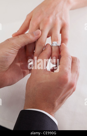 Nahaufnahme des Bräutigams Hand Braut Finger Ring aufsetzen Stockfoto