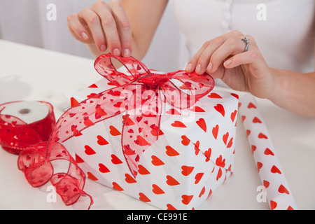 USA, Illinois, Metamora, Nahaufnahme von Frauenhand Verpackung Geschenk zum Valentinstag Stockfoto