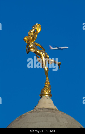 Stadt von London die Statue von Ariel auf der Bank of England, mit einem vorbeifahrenden Flugzeug in der Ferne Januar 2012 Stockfoto