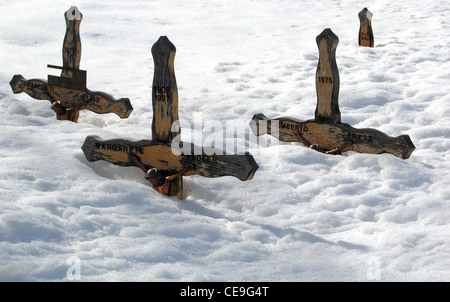 Hölzerne Grabkreuze decken sich im Tiefschnee auf dem Friedhof in Zermatt im Bezirk Visp im Kanton Wallis in den Schweizer Alpen. Stockfoto