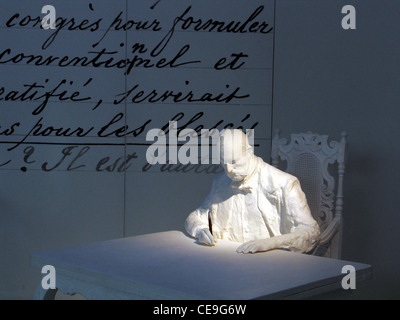 Statue von Jean Henry Dunant 1828 1910 Schweizer Philanthropen und Friedensnobelpreisträger, der auch das Rote Kreuz gründete, sitzend vor seinen Ideen Handschrift über die Schaffung eines Freiwilligenkomitees zur Versorgung von Kriegsverwundeten, bekannt als das Buch A Memory of Solferino, das bei der International ausgestellt wurde das Rote Kreuz- und Rothalbmondmuseum bietet detaillierte fotografische und andere physische Beweise für den Dienst des IKRK an der Menschheit während zahlloser Kriege und Naturkatastrophen in Genf, Schweiz Stockfoto