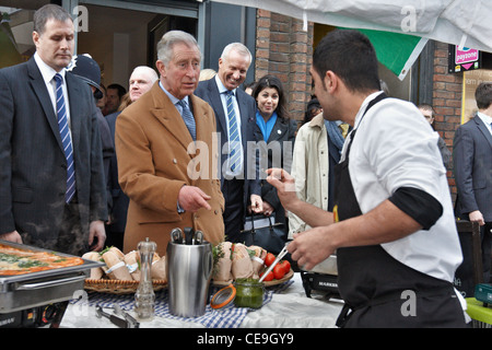 Prinz Charles versucht italienisches Essen, zubereitet von Alessio Garau (rechts) bei einem Besuch in unteren Marsh Markt, Waterloo, London. Stockfoto