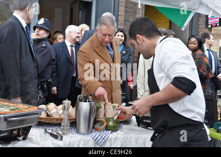 Prinz Charles versucht italienisches Essen, zubereitet von Alessio Garau (rechts) bei einem Besuch in unteren Marsh Markt, Waterloo, London. Stockfoto