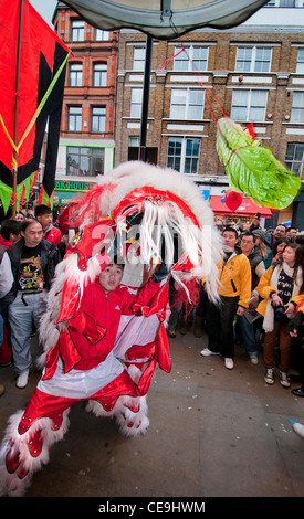 Chinese New Year Tradition wo Löwen Marionette Resta Lebensmittel mit roten Umschlag mit Geld (symbolisiert Glück) gespeist wird Stockfoto