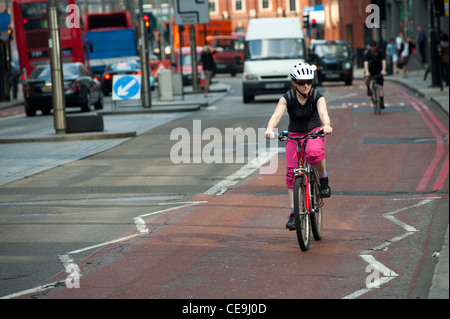 Lady Radfahren eine rote Route in der Mitte der Stadt von London, England. Stockfoto