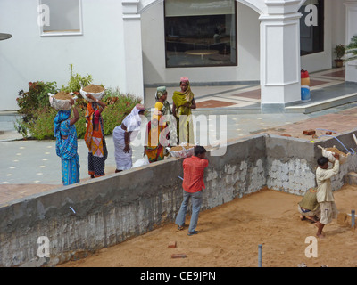 PURI, Indien - NOV 19 - indische Frauen tragen schwere Lasten, während Re Hotelbau am 19. November 2009 in Puri, Indien Stockfoto