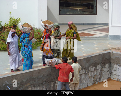 PURI, Indien - NOV 19 - indische Frauen tragen schwere Lasten, während Re Hotelbau am 19. November 2009 in Puri, Indien Stockfoto