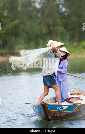 Ein Fischer schwingt seine große gewichteten netto um seinen Kopf und in den Gewässern des Flusses Thu Bon in der Nähe von Hoi an in Vietnam. Stockfoto