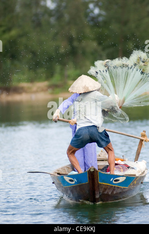 Ein Fischer schwingt seine große gewichteten netto um seinen Kopf und in den Gewässern des Flusses Thu Bon in der Nähe von Hoi an in Vietnam. Stockfoto