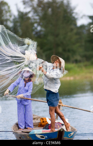 Ein Fischer schwingt seine große gewichteten netto um seinen Kopf und in den Gewässern des Flusses Thu Bon in der Nähe von Hoi an in Vietnam. Stockfoto