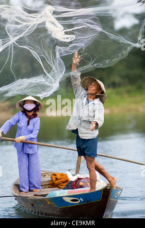 Ein Fischer schwingt seine große gewichteten netto um seinen Kopf und in den Gewässern des Flusses Thu Bon in der Nähe von Hoi an in Vietnam. Stockfoto