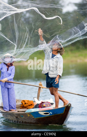 Ein Fischer schwingt seine große gewichteten netto um seinen Kopf und in den Gewässern des Flusses Thu Bon in der Nähe von Hoi an in Vietnam. Stockfoto