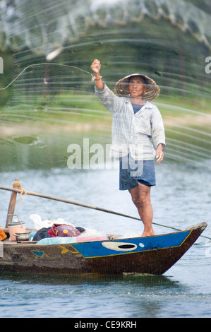 Ein Fischer schwingt seine große gewichteten netto um seinen Kopf und in den Gewässern des Flusses Thu Bon in der Nähe von Hoi an in Vietnam. Stockfoto