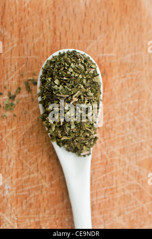 Oregano Gewürz auf Keramik Löffel über eine hölzerne Platte Stockfoto