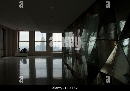 Touristen genießen einen Blick auf das Empire State Building aus dem Rockefeller Center, New York, USA. Stockfoto