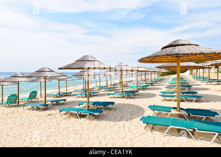 Reihen von Sonnenschirmen am Strand von leer am Meer in Griechenland Stockfoto