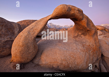 Mobius Arch mit den schneebedeckten Bergen der Sierra Nevada im Hintergrund, Alabama Hills, Kalifornien, USA Stockfoto